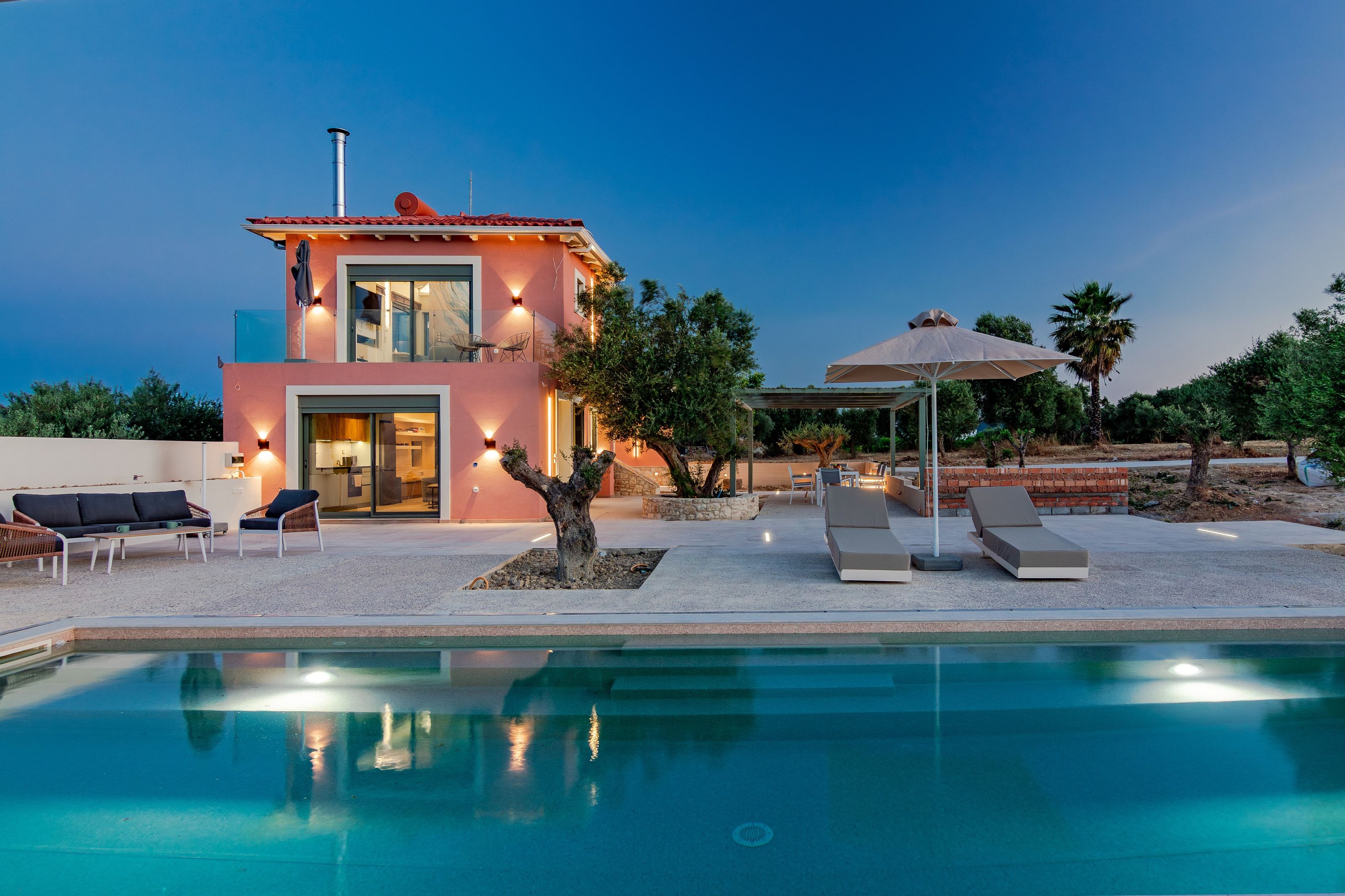The whole estate at dusk: house, pool and terraces