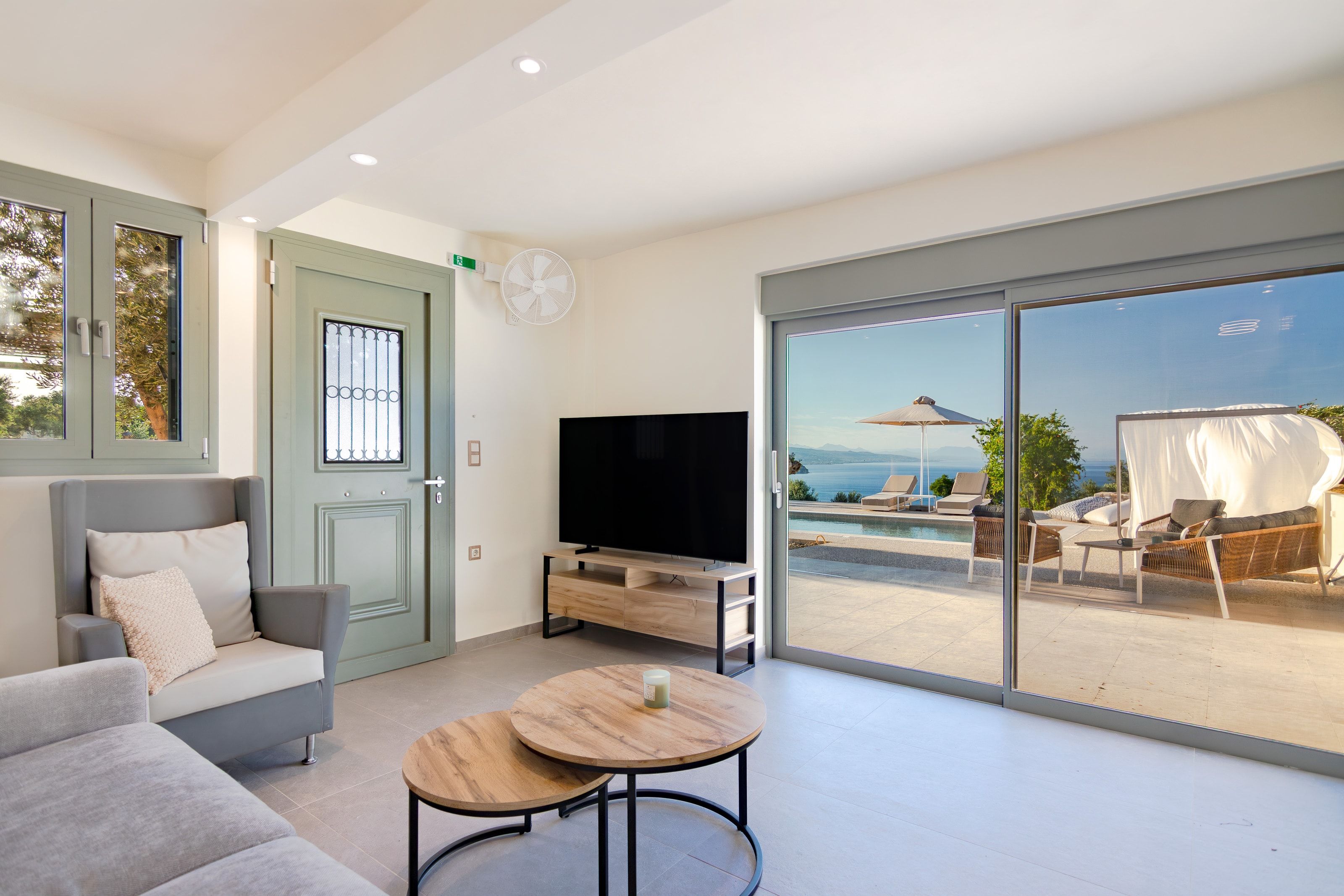 Ground-floor apartment living room with television and pool view