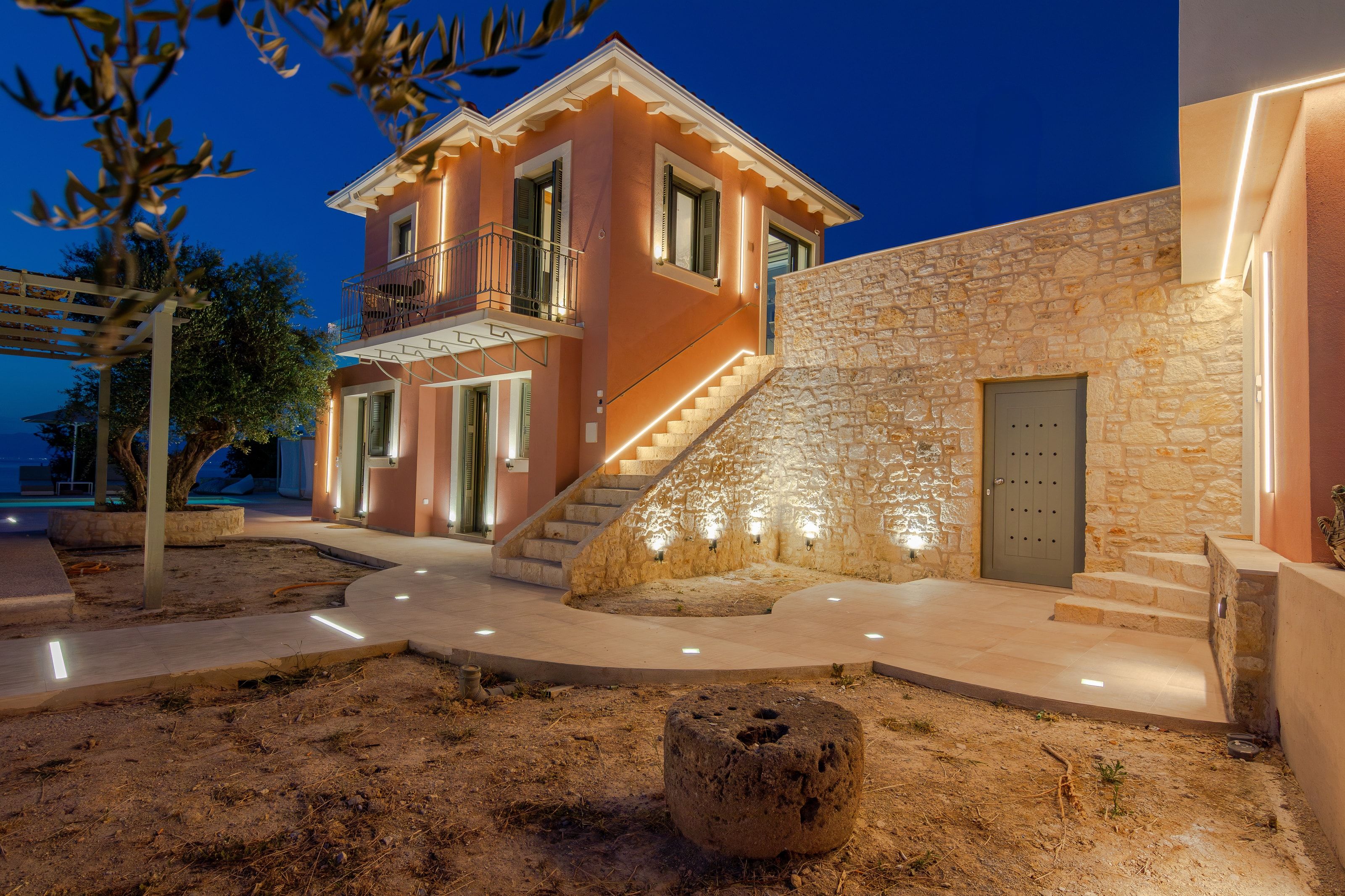 The house at dusk, lit from the garden