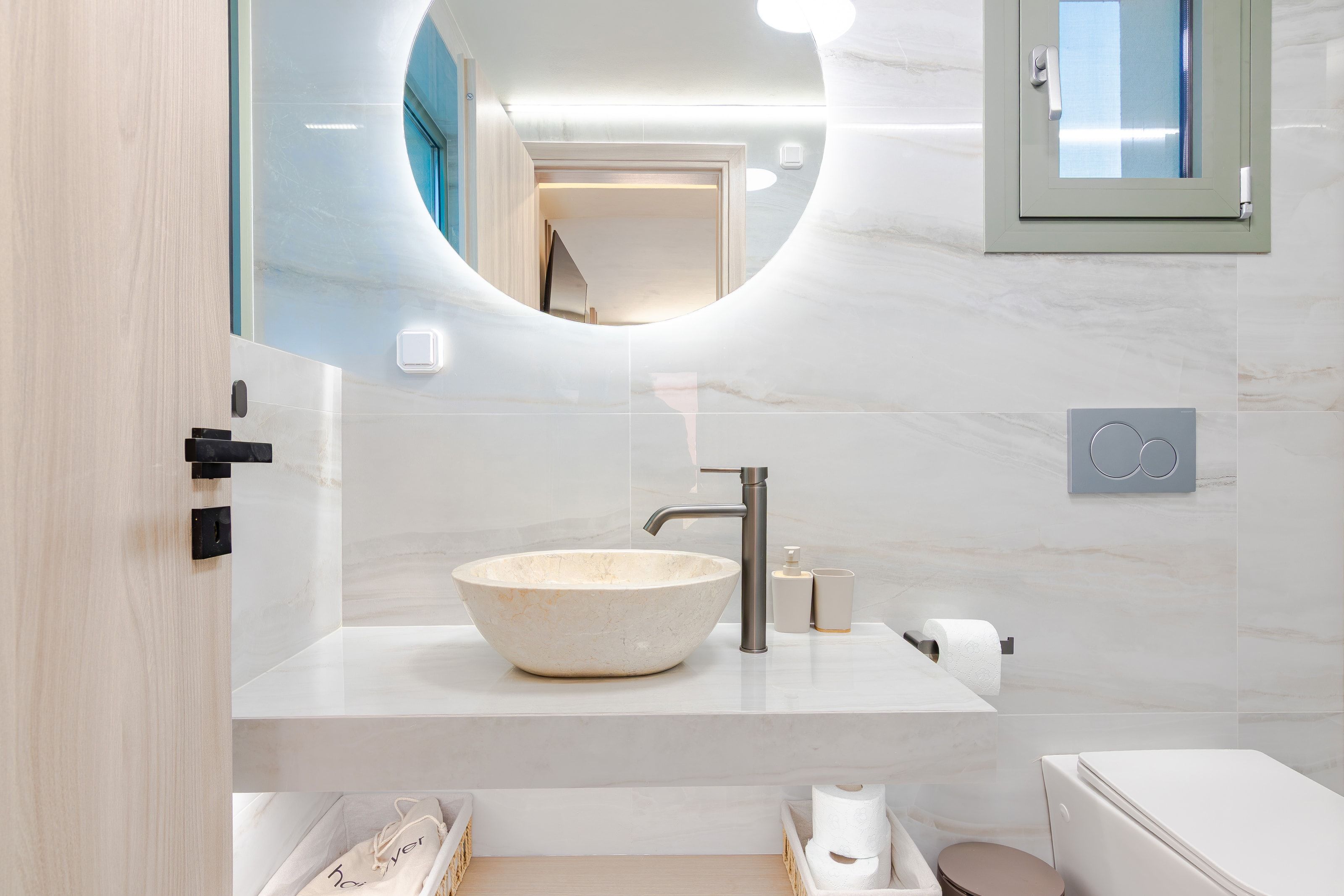 Studio bathroom, round mirror and stone basin